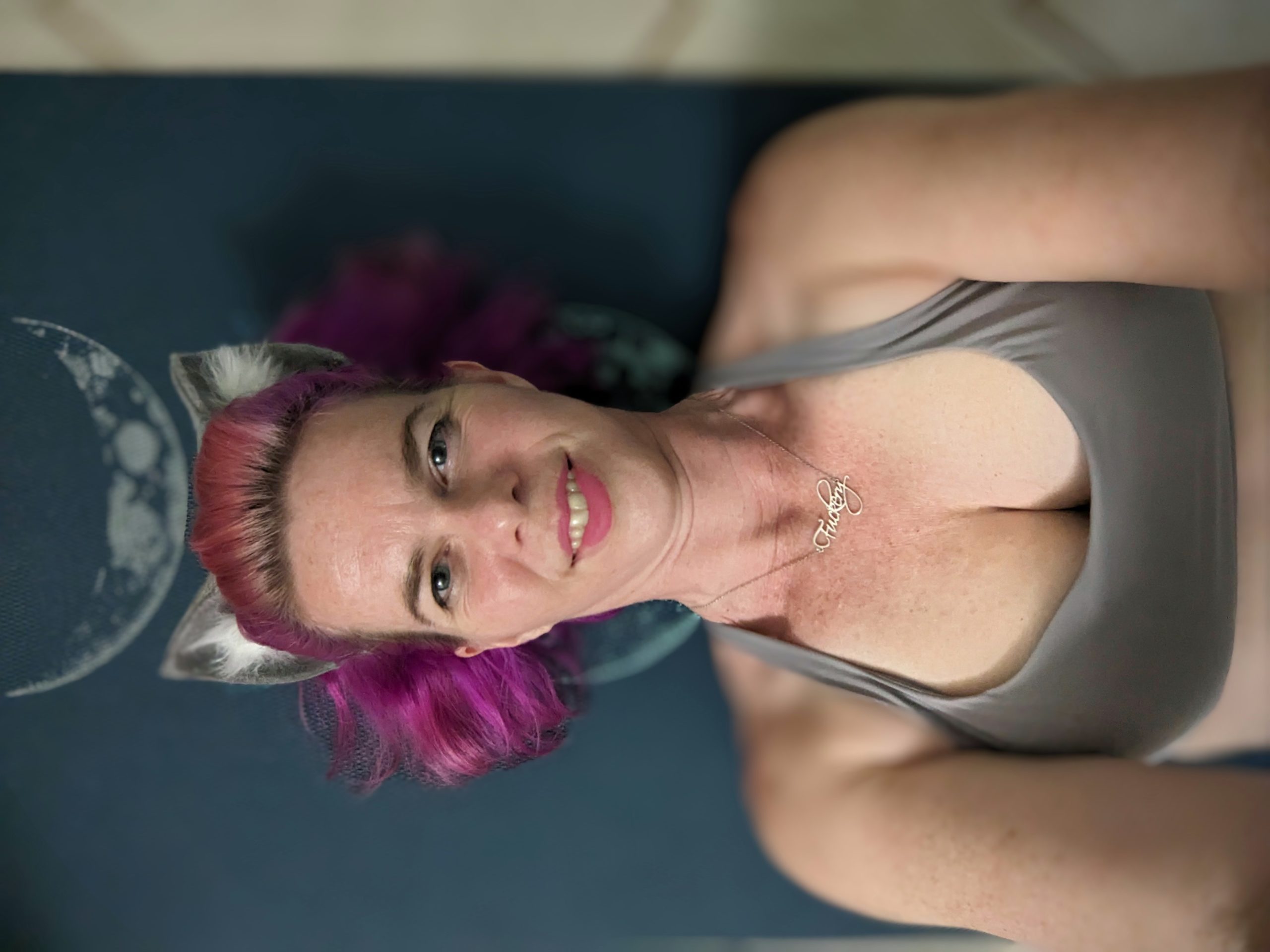 selfie laying on a yoga matt wearing yoga gear and cat ears