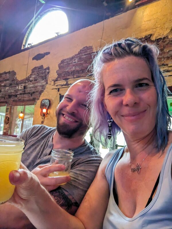 two people holding glasses at a bar